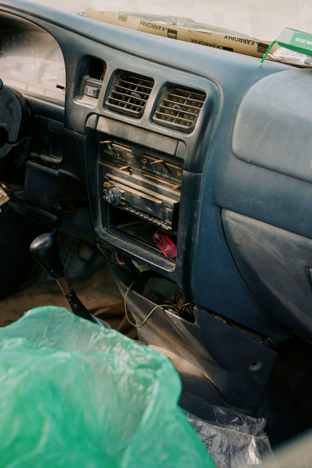 Weathered dashboard and old radio inside a vintage truck in sunlight.