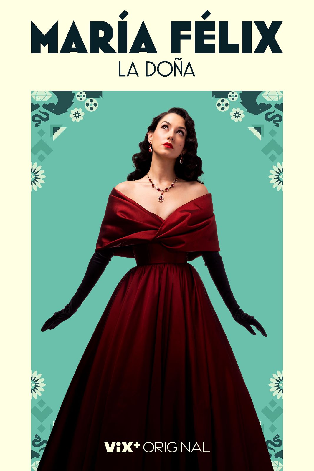 The subject commands the frame in sweeping crimson fabric and dramatic black velvet gloves.