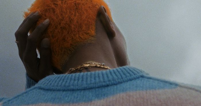Vibrant neon orange hair contrasts beautifully against an overcast Miami sky.