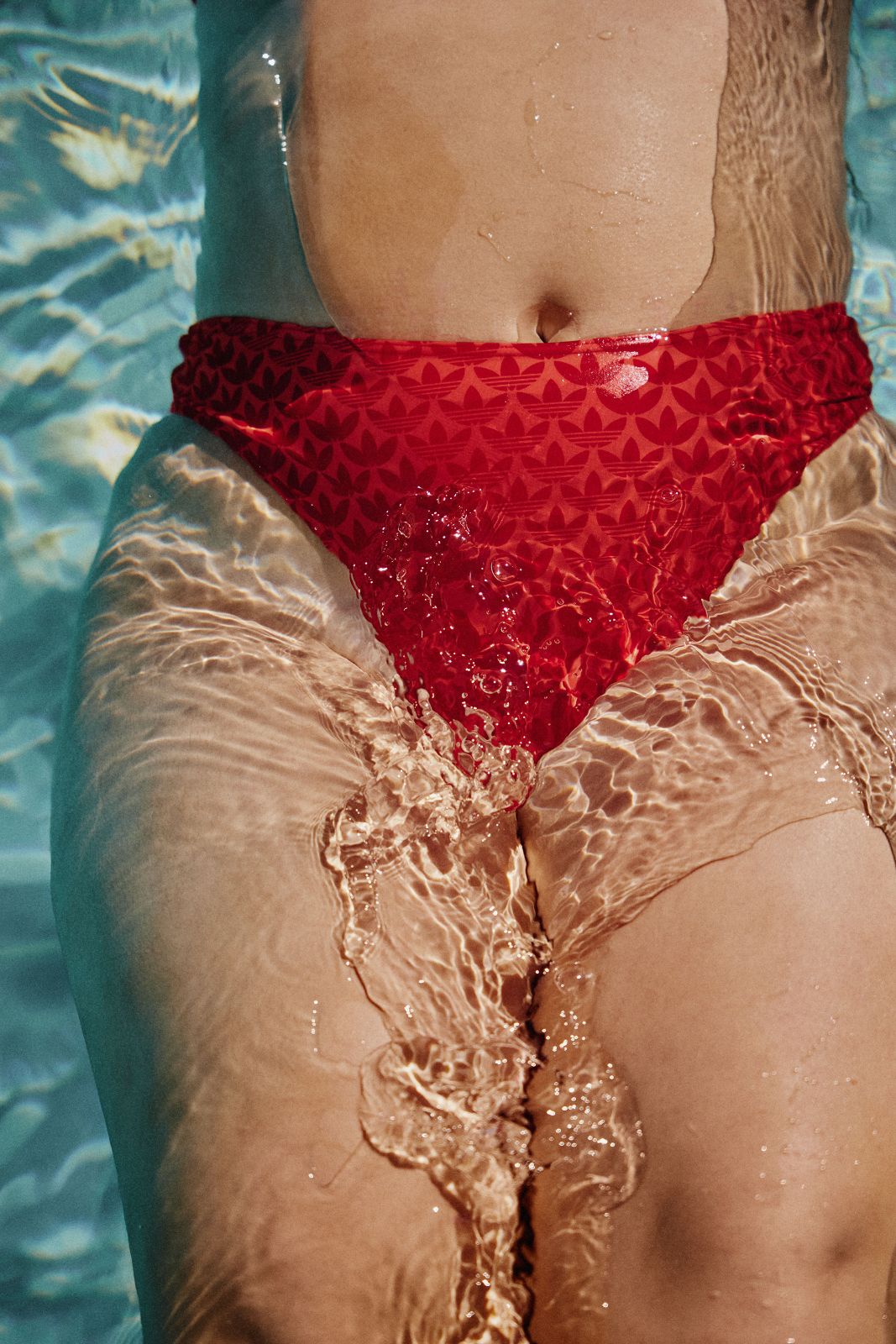 Shimmering golden sunlight beautifully reflecting on red Adidas bikini bottoms