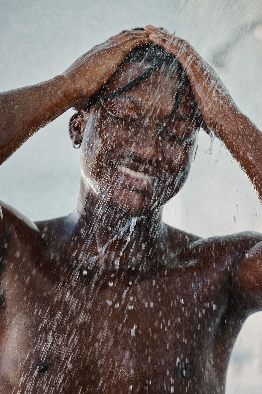 Man washing hair under bright Miami outdoor shower enjoying the fresh water