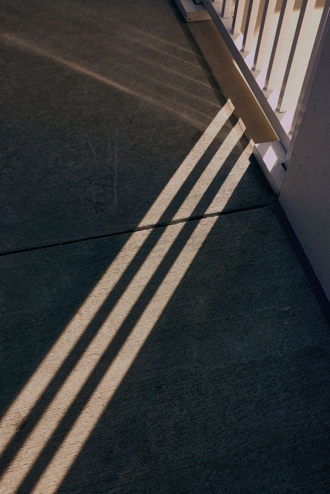 Long rhythmic shadows cast on concrete under harsh Florida afternoon sunlight