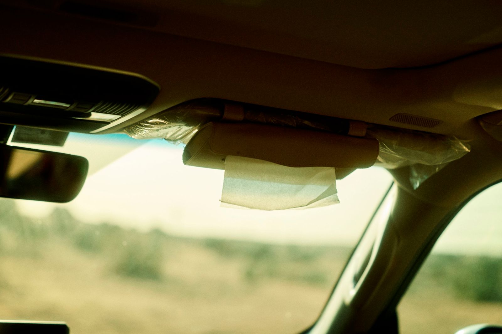 Loose tissues fluttering from the sun visor in the breeze.