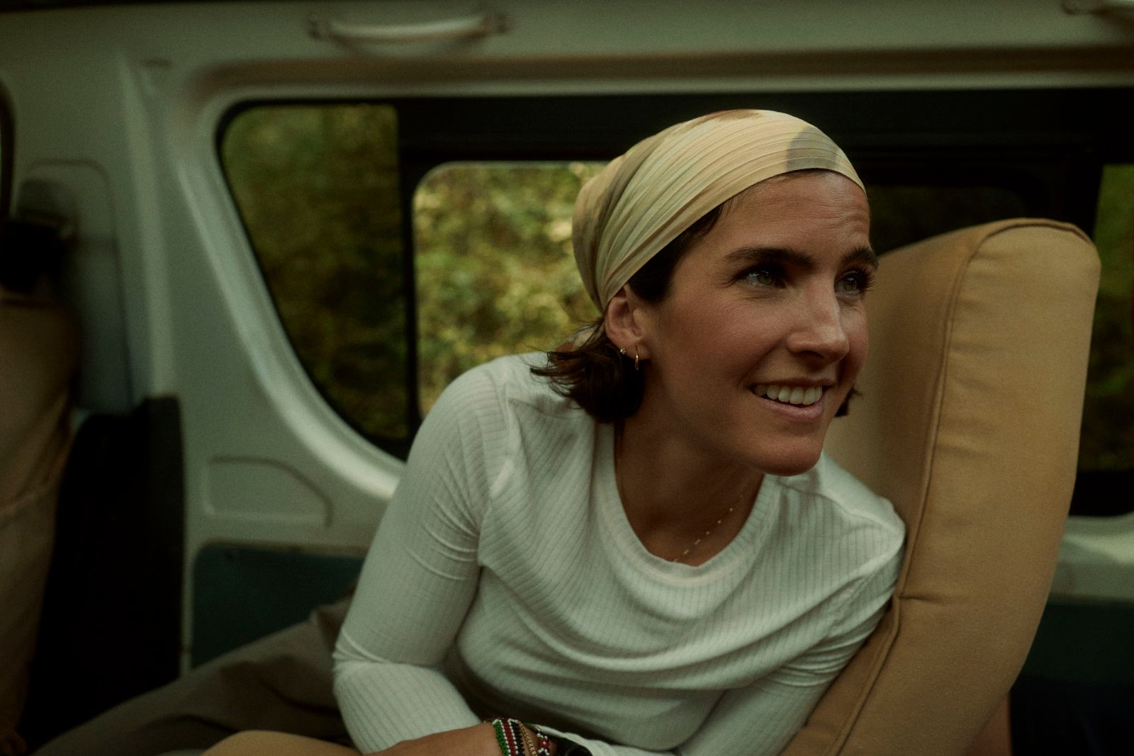A quiet, present smile inside the Land Cruiser.
