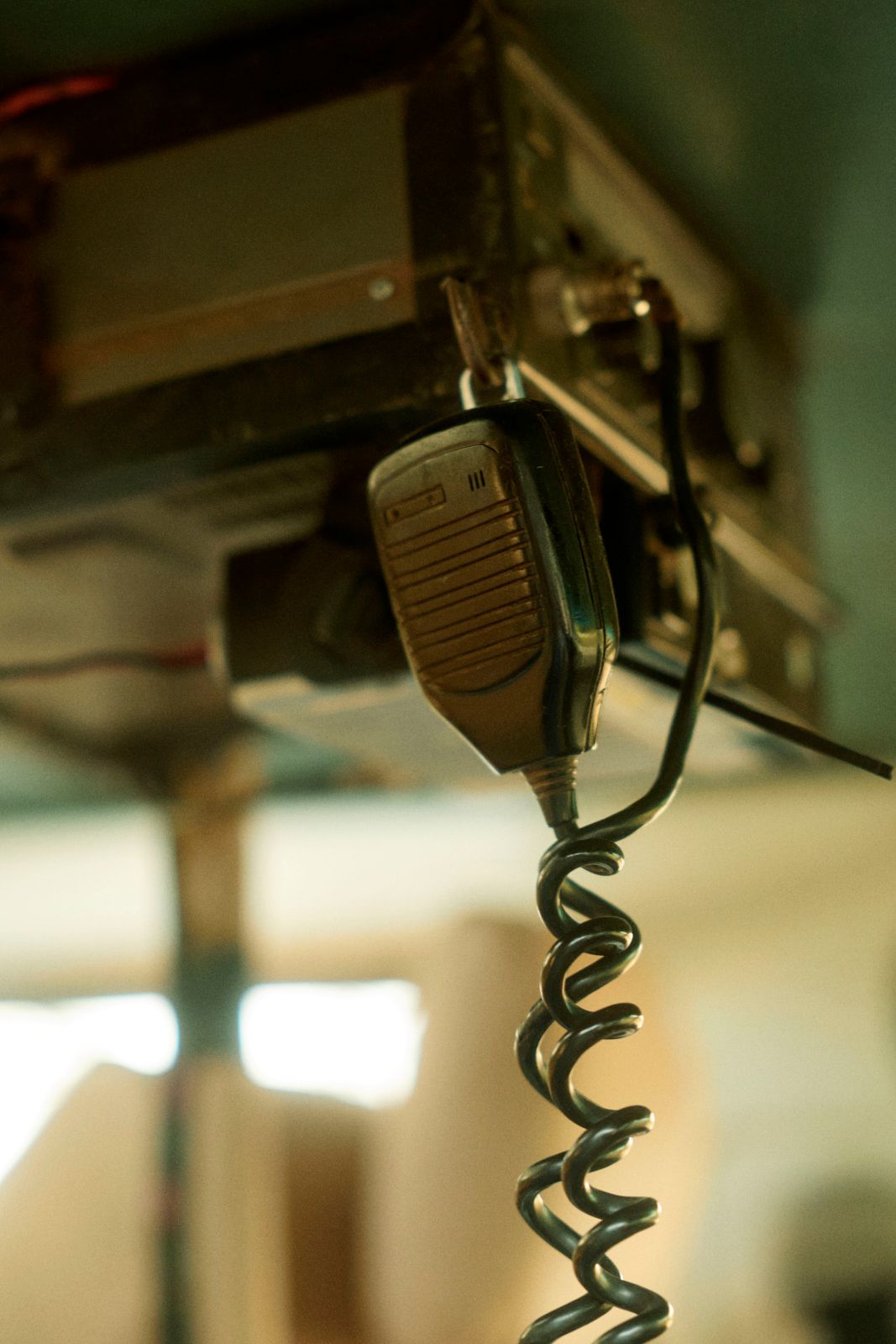 The coiled cord of the two-way walkie-talkie swinging in motion.