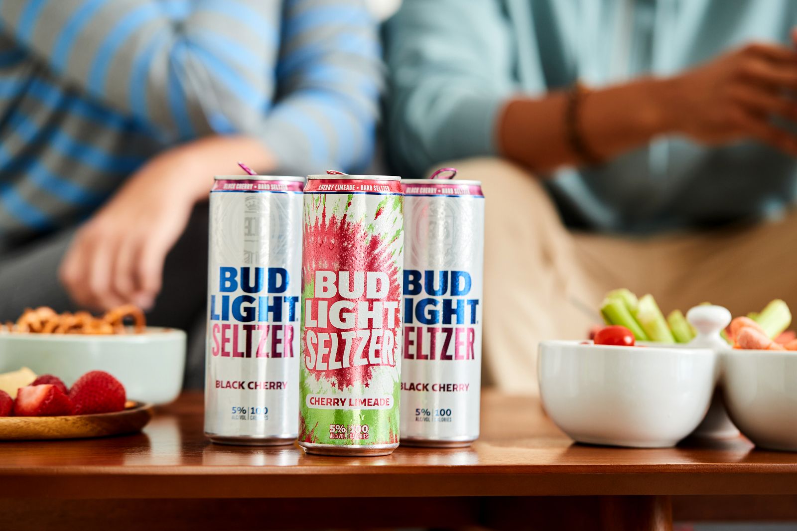 A clustered trio of chilled cans arranged elegantly on a warm wood table.